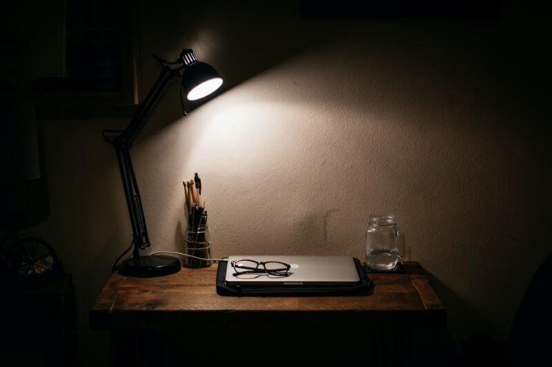 暗い部屋でライトに照らされたノートパソコン