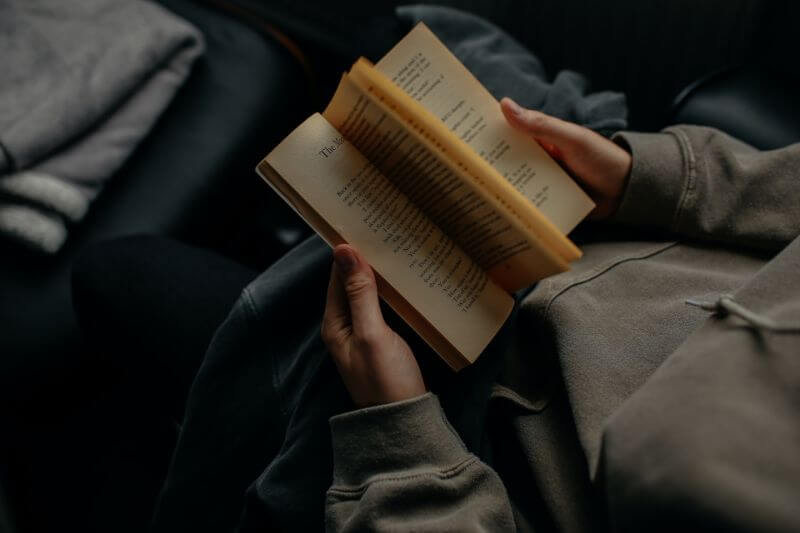 ソファーに座って本を読む男性