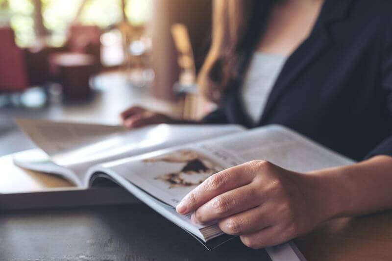 カフェで雑誌を読む女性